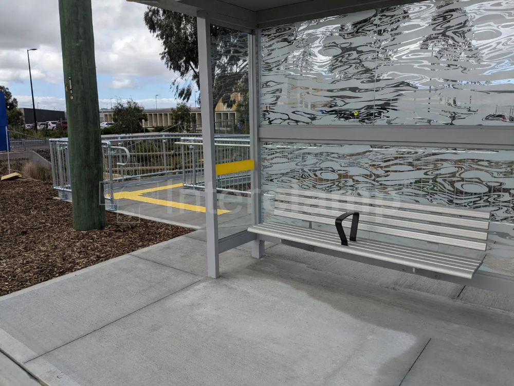 Close-up of Interclamp key clamp DDA assist rail forming part of a safety barrier system at a bus stop, providing secure support for waiting passengers.